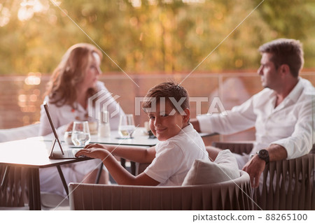 An elderly couple enjoys the terrace of a luxury house with their son during the holidays. Selective focus An elderly couple enjoys the terrace of a luxury house with their son during the holidays. Selective focus 88265100