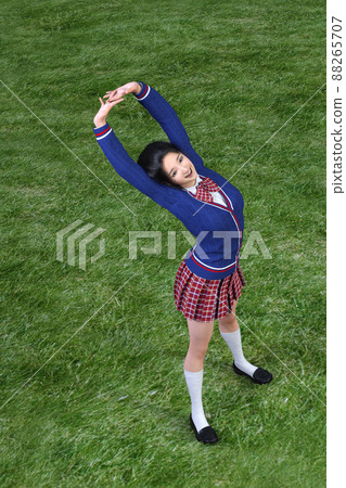 在學校操場的草坪上舒展身體的女高中生。 3D 插圖 3D 渲染 88265707