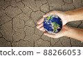 broken world on hands on the dry and cracked ground 88266053