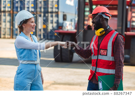 Businesswoman and engineer join hands to work success loading Containers box from Cargo freight ship for import export. Freight containers in sea port. Businesswoman and engineer join hands to work success loading Containers box from Cargo freight ship for import export. Freight containers in sea port. 88267347