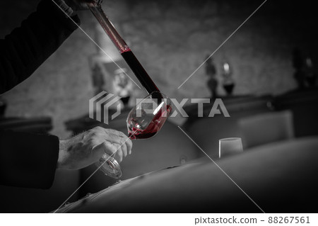 FRANCE, GIRONDE, SAINT-EMILION, SAMPLING A GLASS OF WINE IN A BARREL WITH A PIPETTE FOR TASTING AND 88267561