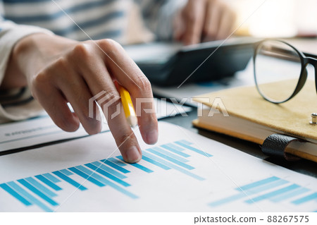 Business woman working in finance and accounting Analyze financial budget with calculator in the office Business woman working in finance and accounting Analyze financial budget with calculator in the office 88267575