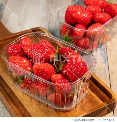 Fresh strawberries in a bowl on wooden table with low key scene Fresh strawberries in a bowl on wooden table with low key scene 88267581