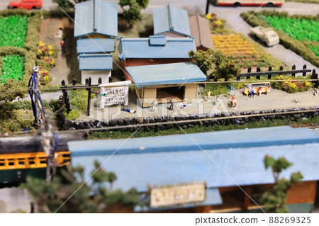 A diorama of a countryside with miniature cars, trains and people A diorama of a countryside with miniature cars, trains and people 88269325
