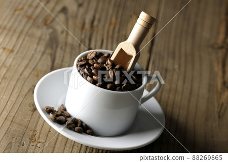 咖啡杯中的咖啡豆和插入其中的量匙 88269865