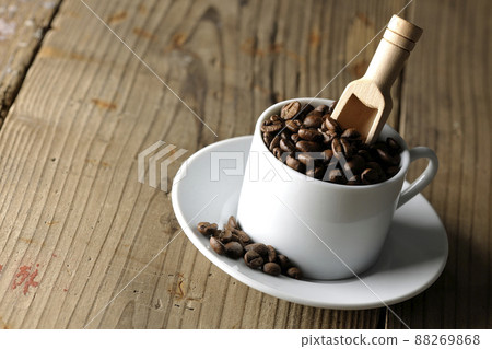 Coffee beans in a coffee cup and a measuring spoon that sticks into it 88269868