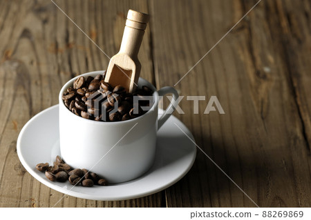 Coffee beans in a coffee cup and a measuring spoon that sticks into it 88269869