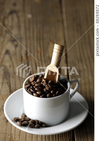 Coffee beans in a coffee cup and a measuring spoon that sticks into it 88269872