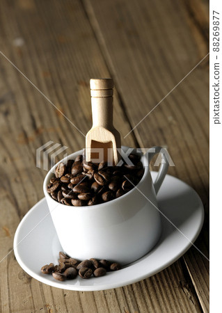 Coffee beans in a coffee cup and a measuring spoon that sticks into it 88269877