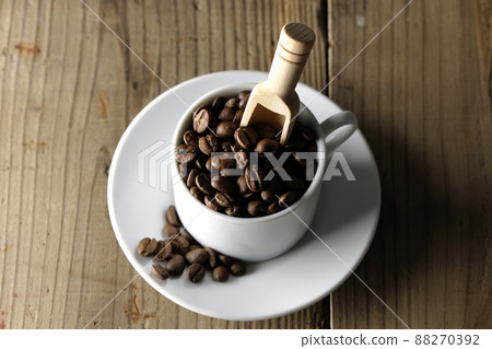 A bird's-eye view of coffee beans in a coffee cup and a measuring spoon stuck in it 88270392