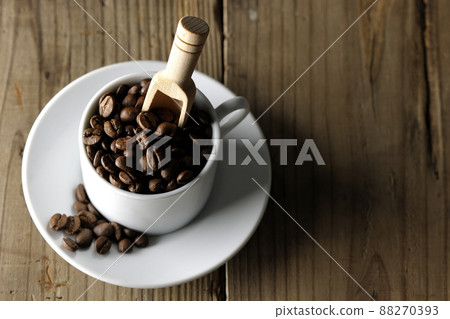 A bird's-eye view of coffee beans in a coffee cup and a measuring spoon stuck in it 88270393