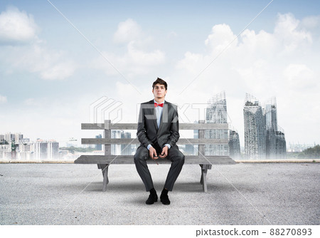 businessman with glasses sits on a wood bench 88270893