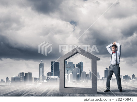 Manager man crashing stone home as symbol for real estate insurance 88270945