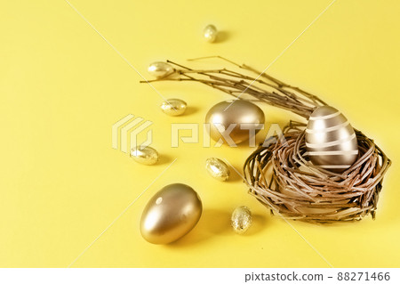 Golden colored Easter eggs in a nest on yellow background. Happy Easter time. Golden colored Easter eggs in a nest on yellow background. Happy Easter time. 88271466
