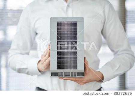 Hands of an Asian man holding an architectural model of a building Hands of an Asian man holding an architectural model of a building 88272689