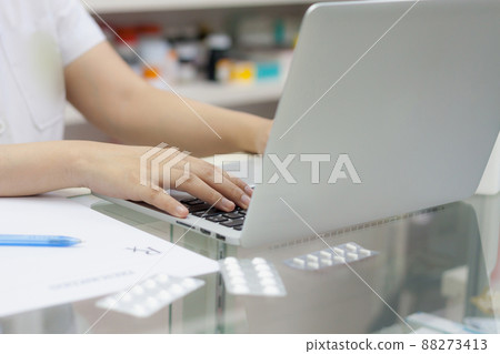 Pharmacist with laptop computer and medication in the pharmacy 88273413