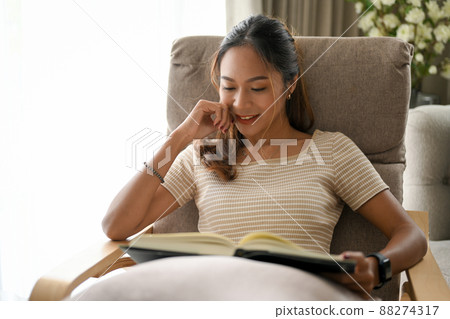 Relaxed Asian woman enjoy reading her favorite novel or book Relaxed Asian woman enjoy reading her favorite novel or book 88274317