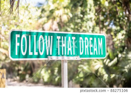 Motivational quote saying Follow That Dream on a sign next to a road in the nature Motivational quote saying Follow That Dream on a sign next to a road in the nature 88275106