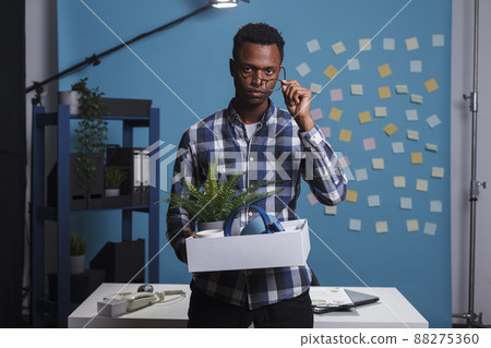 Jobless company worker carrying belongings and thinking about failed career. Entrepreneur getting fired and packing office things to leave job, feeling upset and dissapointed about dismissal. Jobless company worker carrying belongings and thinking about failed career. Entrepreneur getting fired and packing office things to leave job, feeling upset and dissapointed about dismissal. 88275360