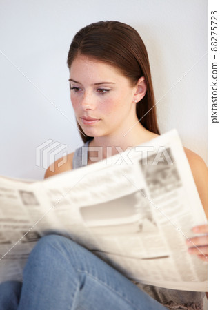 Catching up on daily news. A young woman reading the morning paper. 88275723