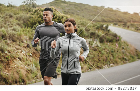 Dont stop until you reach the end. Shot of two sporty young people running outdoors. 88275817