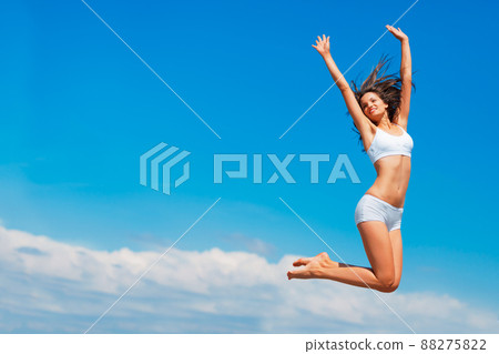 Happy the higher I go. Shot of a happy young woman jumping high in the sky. Happy the higher I go. Shot of a happy young woman jumping high in the sky. 88275822