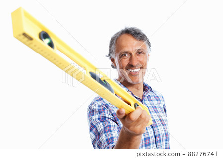Smiling architect holding spirit-level. Portrait of smiling mature architect holding spirit-level over white background. 88276741