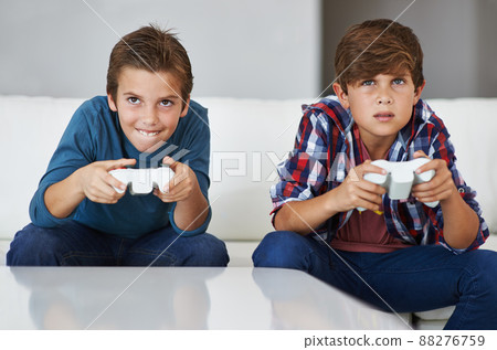 Im gonna beat you. Shot of two young boys concentrating while playing video games. 88276759