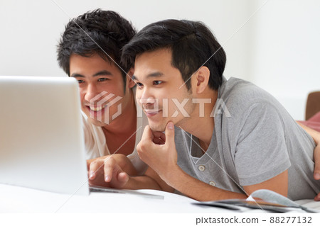 Finding everything theyre looking for.... Two young Asian guys searching the internet together on a laptop. Finding everything theyre looking for.... Two young Asian guys searching the internet together on a laptop. 88277132