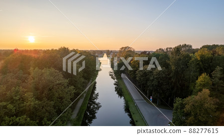 Beautiful sunset over a river with green bushes and color rich sky Beautiful sunset over a river with green bushes and color rich sky 88277615