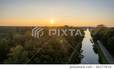 Beautiful sunset over a river with green bushes and color rich sky 88277618