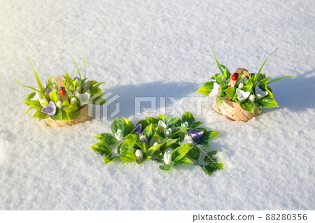 Bouquets of artificial flowers and soaps on lush snow Bouquets of artificial flowers and soaps on lush snow 88280356