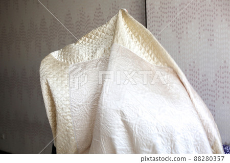 Muslim woman housewife lays a bedspread on the bed Muslim woman housewife lays a bedspread on the bed 88280357