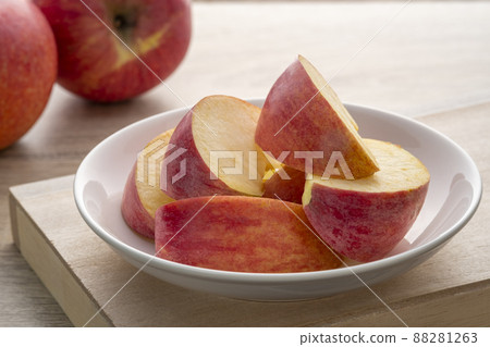 Fresh red apples sliced in white plate on wood background 88281263