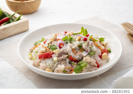 Spicy Glass Noodle Salad with Minced Pork (Yum woon sen) is a type of Thai salad made with clear bean vermicelli and meat in white plate 88281301