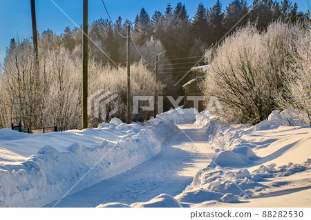 Rural road is cleared of snowdrifts in northern Europe. 88282530