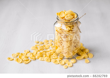 Corn flakes in a glass jar on white wooden surface. Place for your text Corn flakes in a glass jar on white wooden surface. Place for your text 88282769