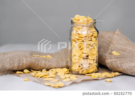 Corn flakes in a glass jar on white wooden surface. Place for your text Corn flakes in a glass jar on white wooden surface. Place for your text 88282770