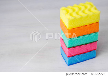 Multicolored sponges for cleaning and washing dishes on a white table. Space for text Multicolored sponges for cleaning and washing dishes on a white table. Space for text 88282773