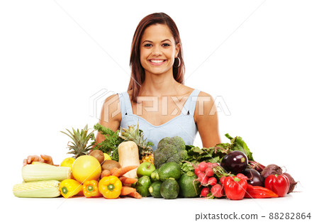 Feeling great about healthy choices. Smiling young woman alongside an assortment of healthy and fresh vegetables. Feeling great about healthy choices. Smiling young woman alongside an assortment of healthy and fresh vegetables. 88282864