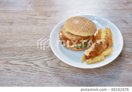 fried mashed chicken cheese hamburger with French fries dressing mayonnaise and ketchup sauce on plate 88282876