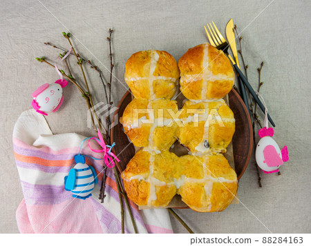 Hot cross buns on plate linen cloth Easter eggs table top view. Traditional sweet pastry. Christian holidays Good Friday 88284163