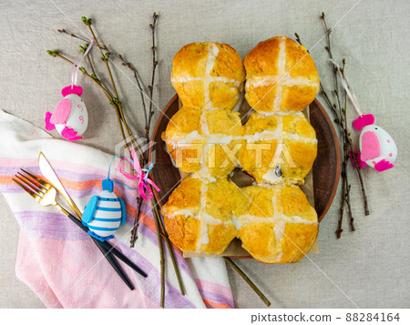 Hot cross buns on plate linen cloth Easter eggs table top view. Traditional sweet pastry. Christian holidays Good Friday Hot cross buns on plate linen cloth Easter eggs table top view. Traditional sweet pastry. Christian holidays Good Friday 88284164