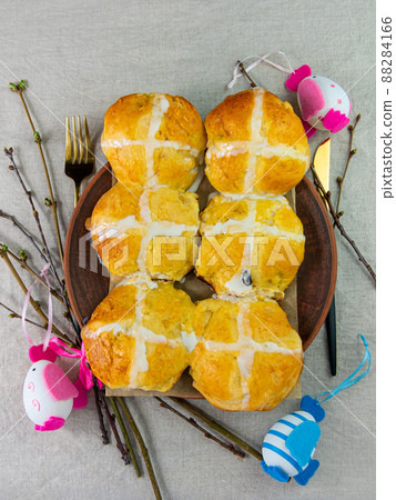 Hot cross buns on plate linen cloth Easter eggs table top view. Traditional sweet pastry. Christian holidays Good Friday 88284166