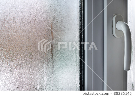 Glass of window with condensation, natural water drops on glass, high humidity. Blurred. 88285145