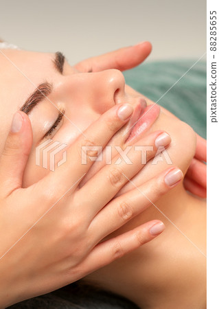 Face massage of detox therapy for the pretty female patient at spa salon 88285655