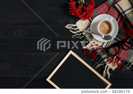 White cup of the coffee and vintage scarf on black wooden background White cup of the coffee and vintage scarf on black wooden background 88286178