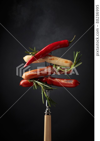 Various sausages with rosemary, and hot pepper. 88286995
