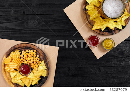 Lager beer and snacks on black wooden table. Nuts, chips. Top view with copyspace 88287079