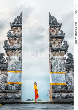 Young woman tourist visiting Lempuyang Temple, Bali Indonesia. History and religion Young woman tourist visiting Lempuyang Temple, Bali Indonesia. History and religion 88287162
